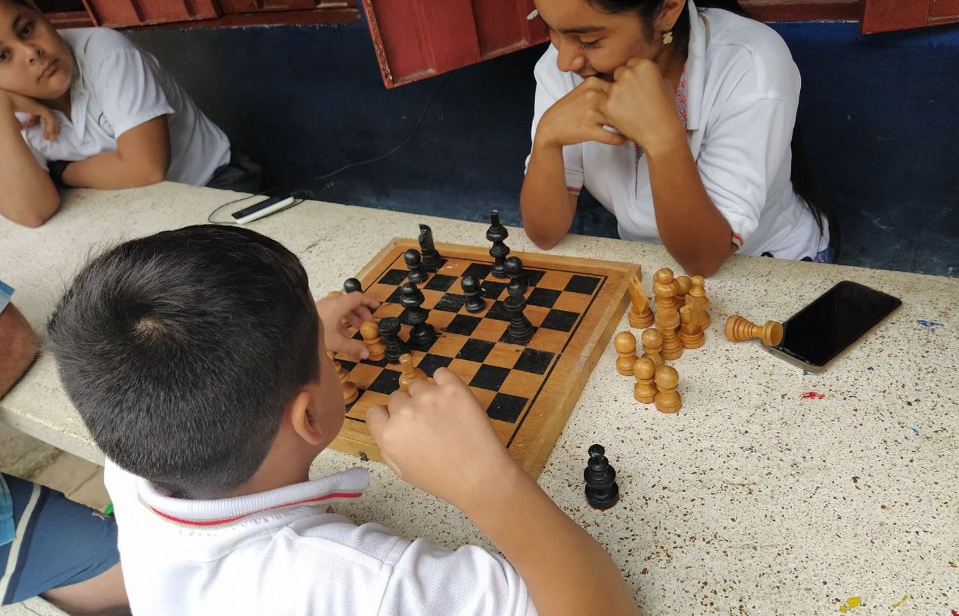 Nina observando un tablero de ajedrez durante una actividad