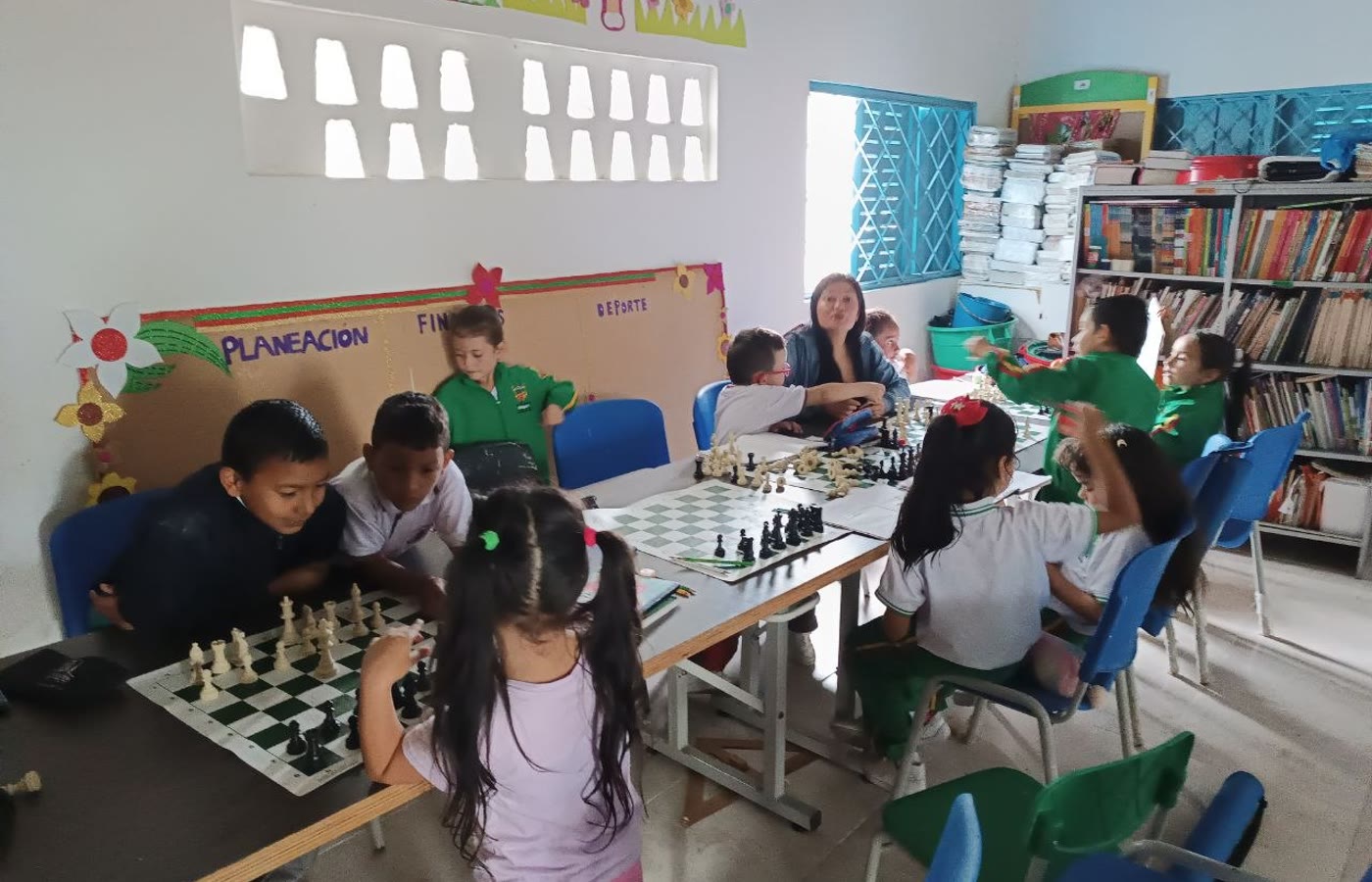 Actividad de ajedrez en un aula rural con varios estudiantes