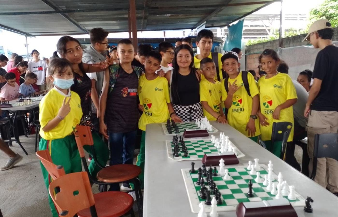 Grupo de estudiantes y tableros durante un torneo escolar